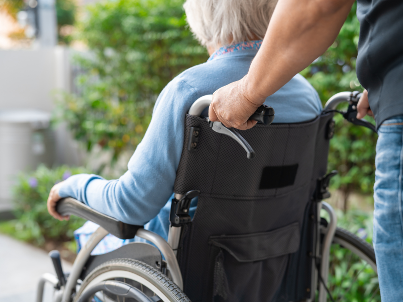 Caregiver assisting person in wheelchair